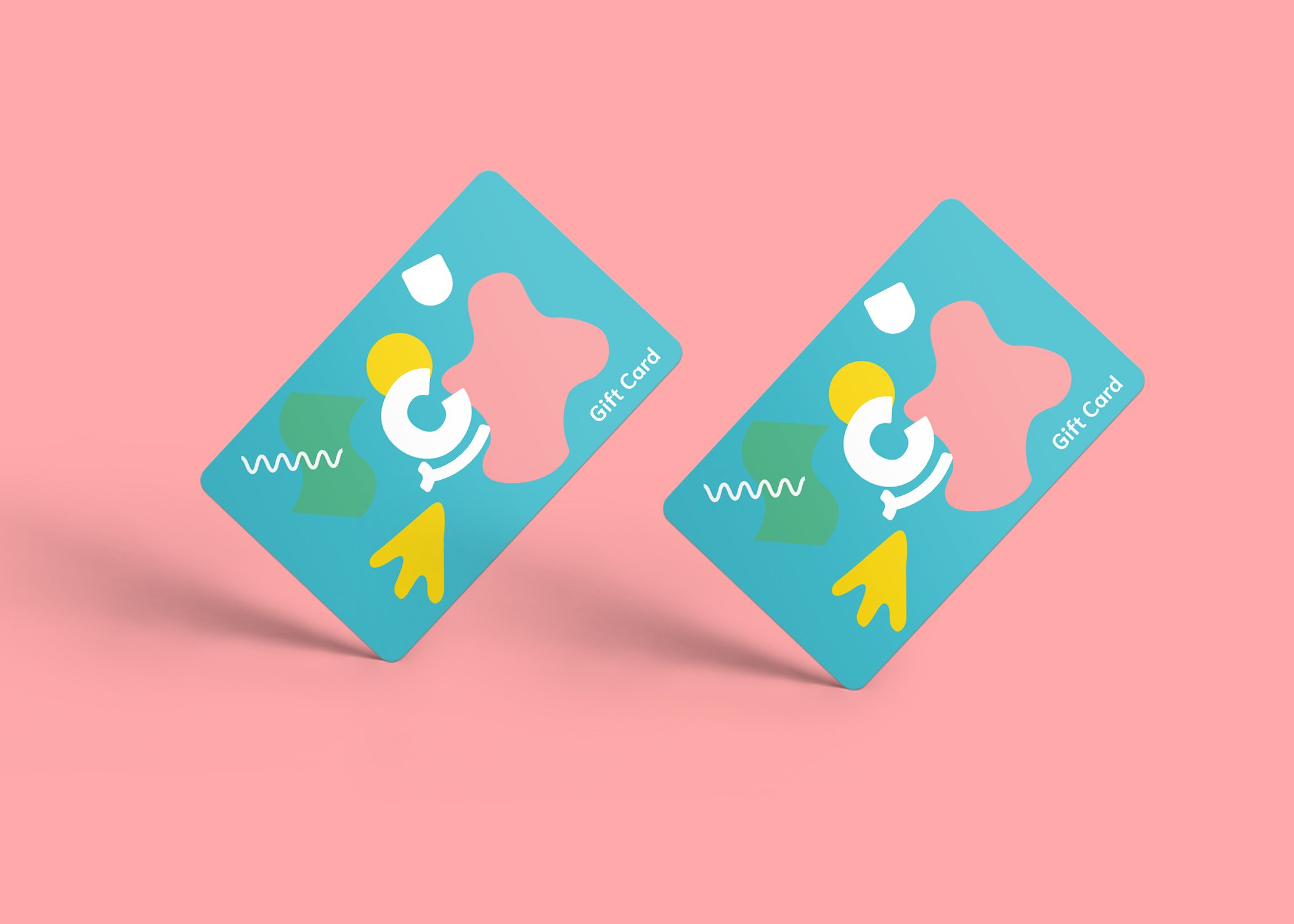 Two colourful gift cards with abstract shapes rest on a pink background. The teal cards feature “Gift Card” in white, symbolising scalable growth strategies for start-ups and the creative spirit of Growth by Design.