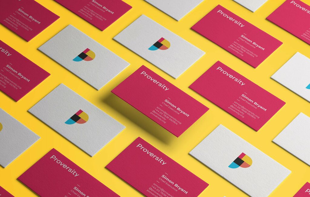 Multiple business cards are arranged on a yellow surface. The white cards feature a colourful geometric "P" logo, while the pink ones display "Proversity" and contact details—perfect for showcasing Growth by Design and creative that converts.