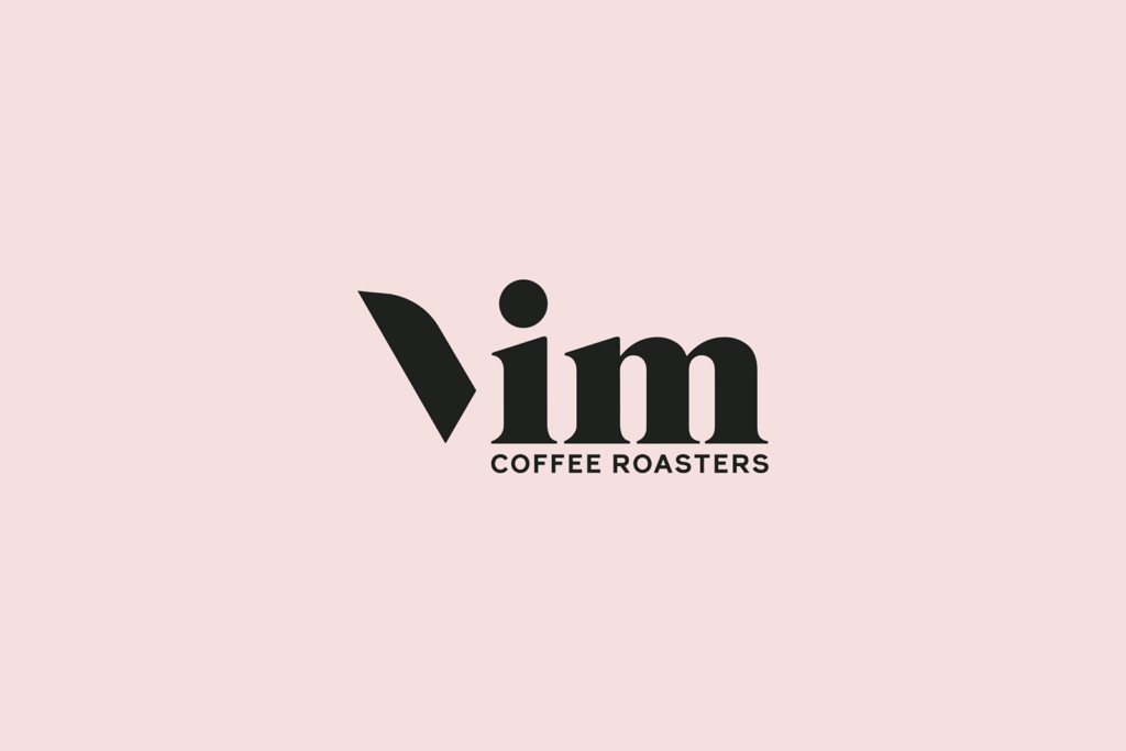 Logo for Vim Coffee Roasters on a pale pink background. Designed by a strategically‑led branding studio, the bold black "V" is followed by "im" in lowercase, with "COFFEE ROASTERS" in smaller uppercase letters underneath.