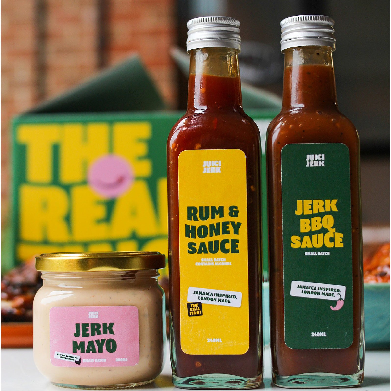 Three condiment jars are displayed—a small "Jerk Mayo" jar and two tall bottles, "Rum & Honey Sauce" and "Jerk BBQ Sauce"—with vibrant labels, exemplifying Growth by Design from a strategically‑led branding studio.
