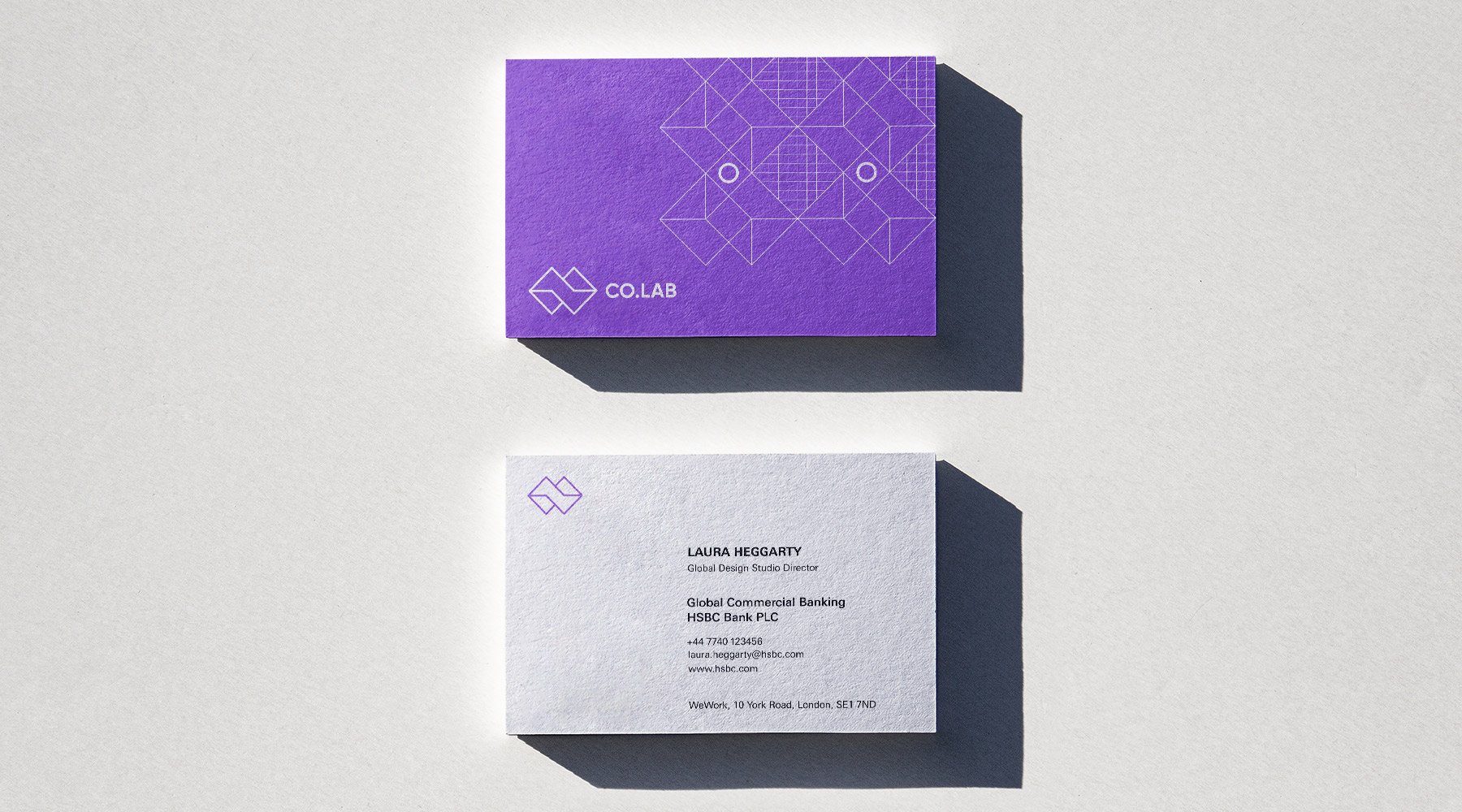 Two business cards on a white surface: the top card is purple with geometric line patterns, featuring the "COLAB" logo and the tagline "Growth by Design;" the bottom card is white with contact details for Laura Neganday at HSBC Bank.